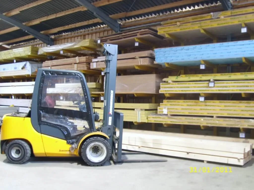 Ein Gabelstapler vor Holzbrettern